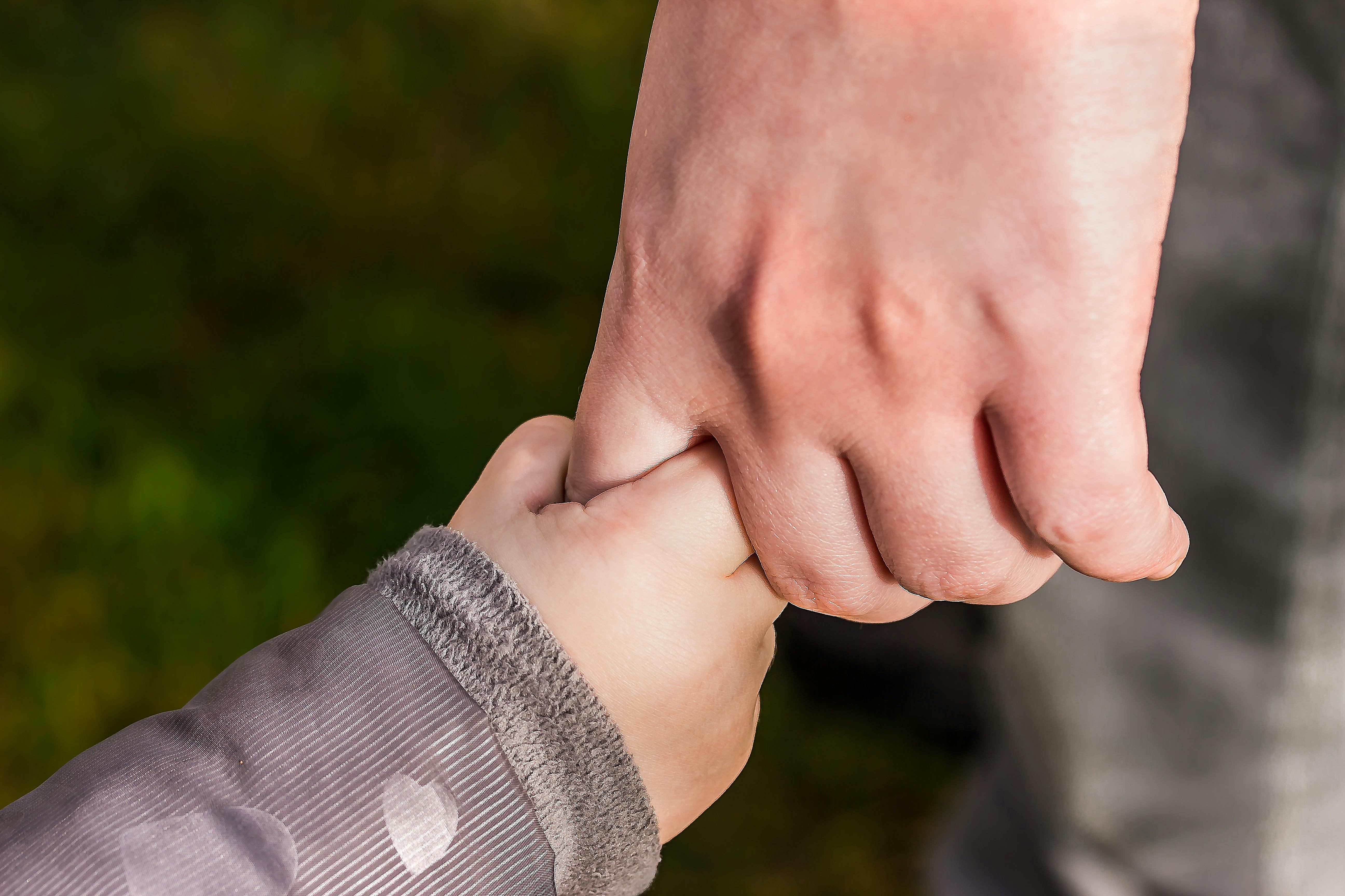 Child and parent holding hands — generational healing