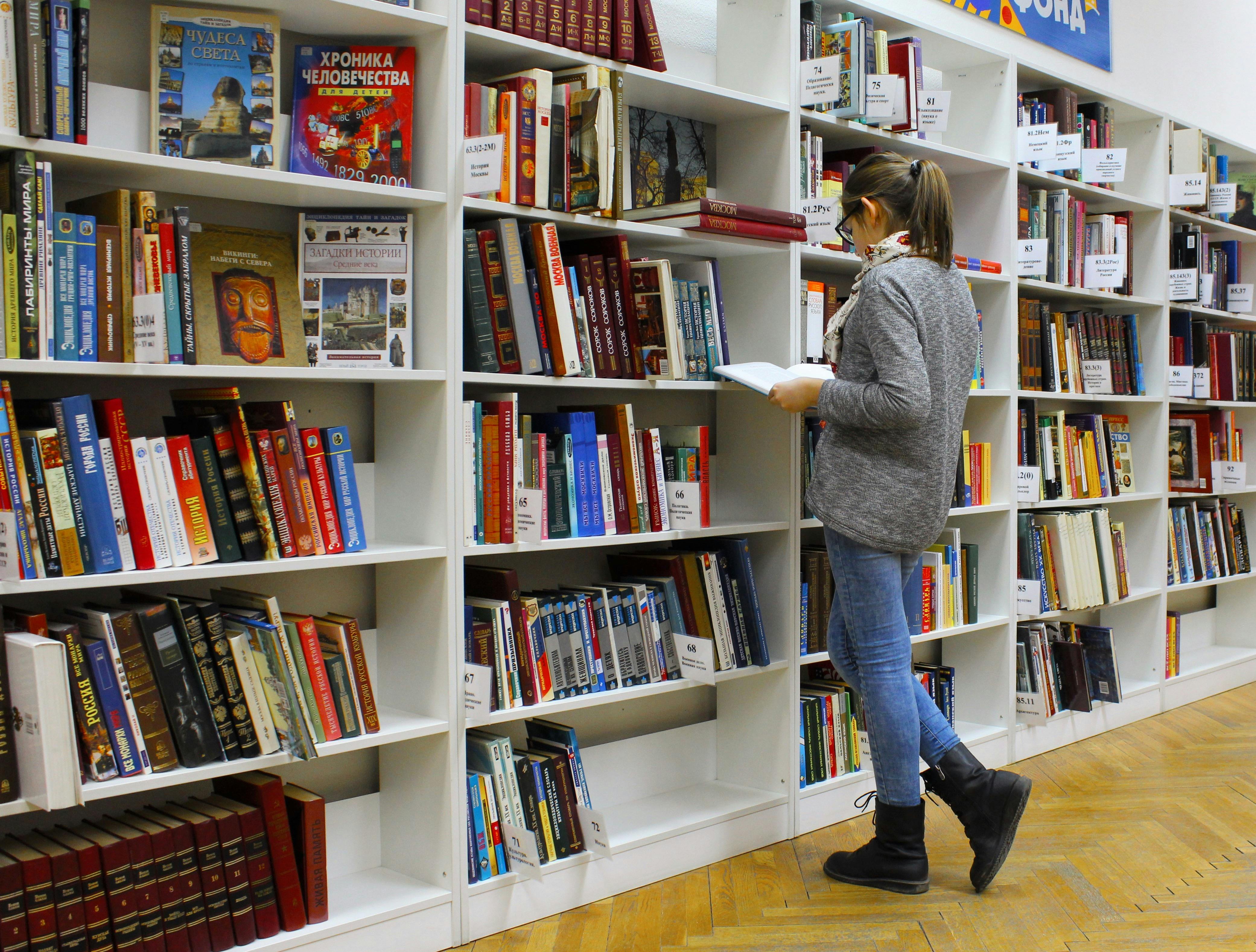 Woman browsing books in library — first-gen self-discovery